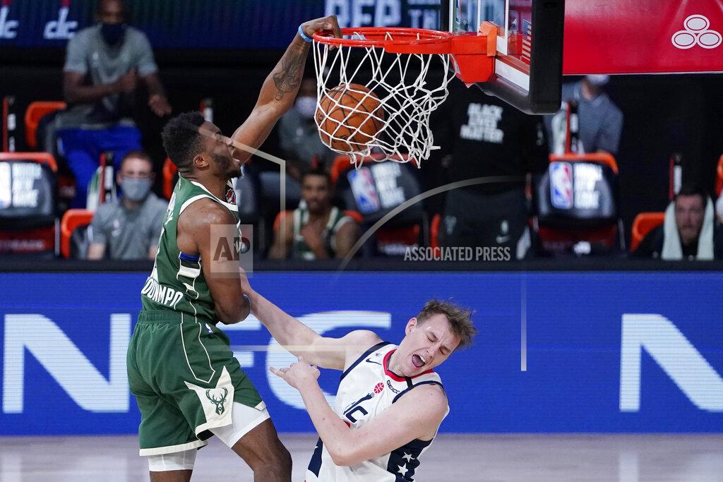 Ashley Landis Milwaukee Bucks' Thanasis Antetokounmpo, left, slams a dunk over Washington Wizards' Anzejs Pasecniks (18) during the second half of an NBA basketball game, Tuesday, Aug. 11, 2020, in Lake Buena Vista, Fla. (AP Photo/Ashley Landis, Pool)