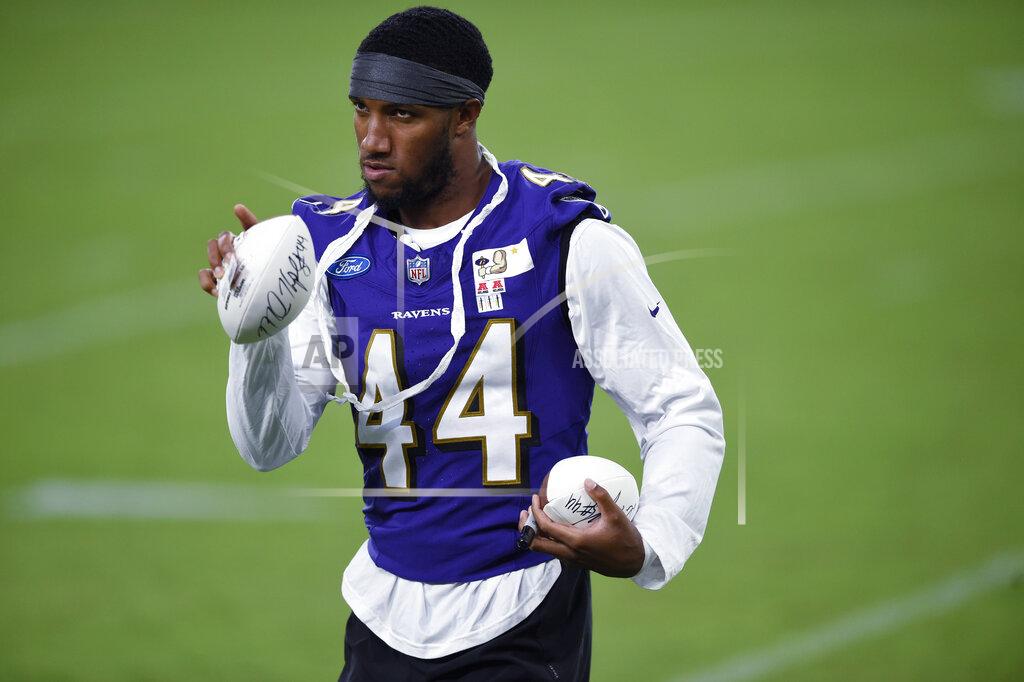 Gail Burton Baltimore Ravens' Marlon Humphreys points to a fan before throwing an autographed football, after practice at NFL football training camp Saturday, July 31, 2021, in Baltimore. (AP Photo/Gail Burton)