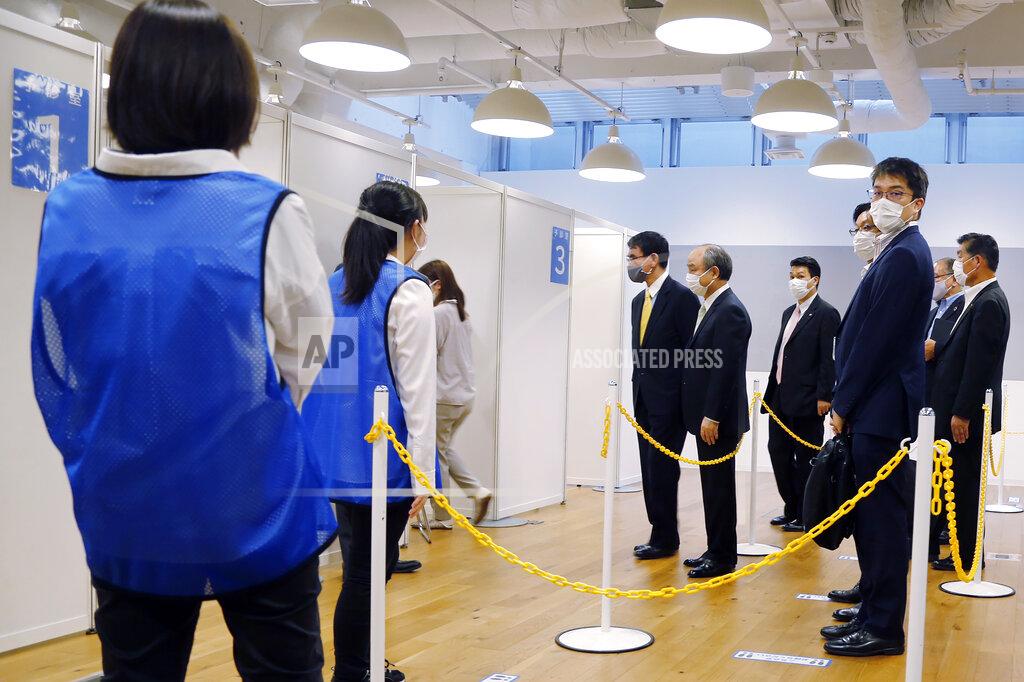 Yuri Kageyama Covid 19 Vaccine Minister Taro Kono, center left, and Masayoshi Son, chief executive of technology company SoftBank Group Corp., center right, visit an inoculation site set up by Japanese technology company SoftBank Group Corp. at a WeWork office Tuesday, June 15, 2021, in Tokyo. Japanese companies have joined the effort to speed up the country’s lagging coronavirus vaccine rollout before the Tokyo Olympics begin next month. (AP Photo/Yuri Kageyama)