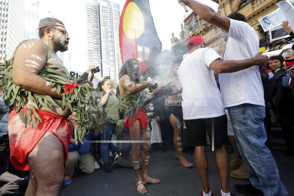 Aboriginal men perform a smoking ceremony as protestors gather in Sydney, Saturday, June 6, 2020, to support the cause of U.S. protests over the death of George Floyd. Black Lives Matter protests across Australia proceeded mostly peacefully as thousands of demonstrators in state capitals honored the memory of George Floyd and protested the deaths of indigenous Australians in custody. (AP Photo/Rick Rycroft)