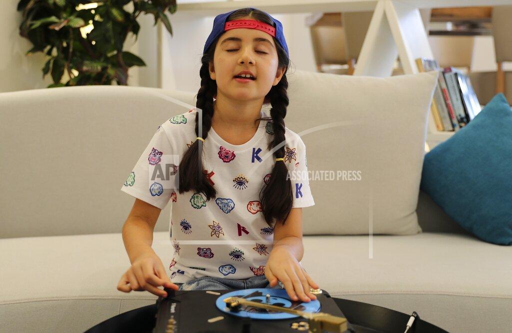Kamran Jebreili Michelle Rasul enjoys scratching her turntable in the lobby of her apartment building in Dubai, United Arab Emirates, Sunday, May 9, 2021. Rasul, a 9-year-old girl from Azerbaijan who lives in Dubai, is scratching her way to the top as a DJ after competing in the DMC World DJ Championship. (AP Photo/Kamran Jebreili)