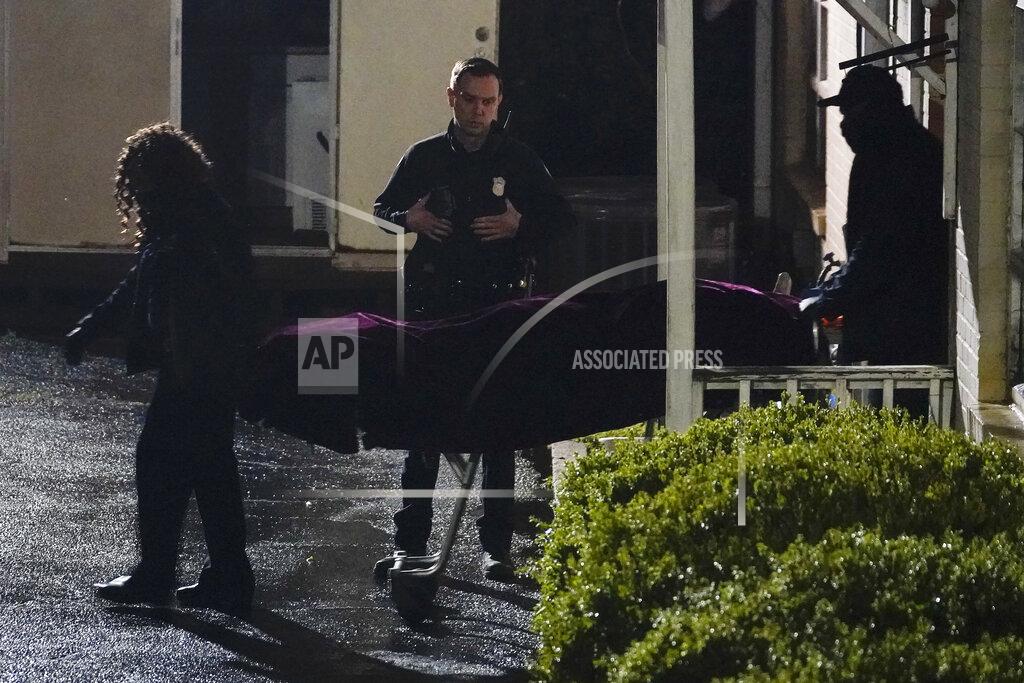 Brynn Anderson A police officer watches as a body is taken from the Gold Spa massage parlor after a shooting, late Tuesday, March 16, 2021, in Atlanta. Shootings at two massage parlors in Atlanta and one in the suburbs left multiple people dead, many of them women of Asian descent, authorities said. A 21-year-old man suspected in the shootings was taken into custody in southwest Georgia hours later after a manhunt, police said. (AP Photo/Brynn Anderson)