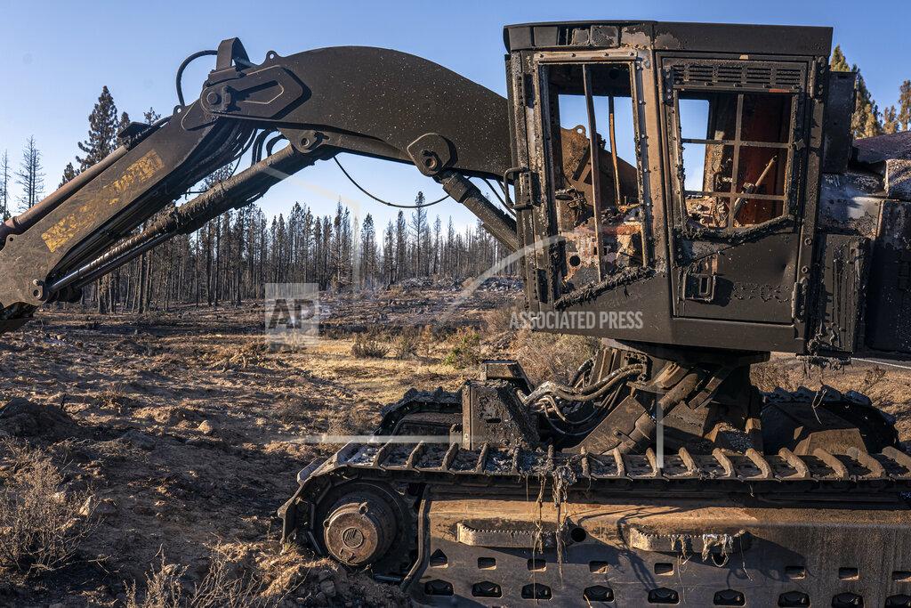 Nathan Howard A damaged and abandoned excavator is seen in an area burned by the Bootleg Fire on Wednesday, July 21, 2021 in Bly, Ore. (AP Photo/Nathan Howard)