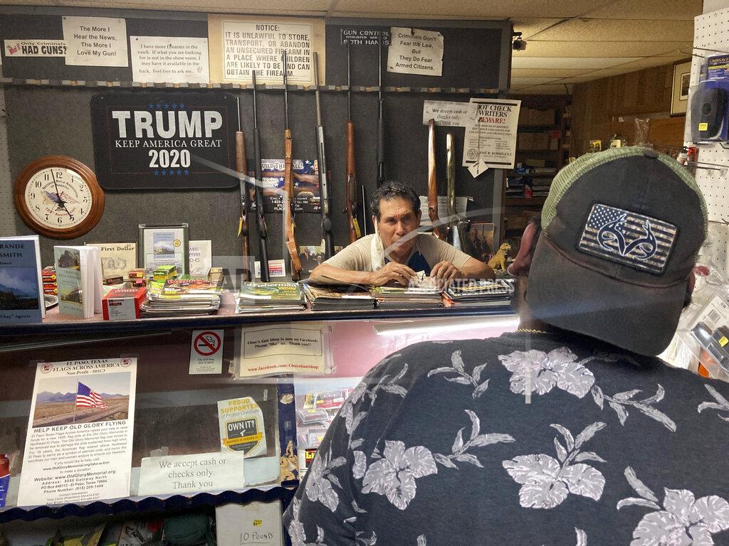 Morgan Lee Gun shop owner Jesus "Chuy" Aguirre, facing camera, attends to customer Angel Zacarias, foreground, on Thursday, Aug. 26, 2021, in Chuy's Gun Shop in El Paso, Texas, as anticipation builds regarding a new Texas law that relaxes restrictions on handguns. Under the new law, most people age 21 or older who have not been convicted of a felony can carry a holstered handgun — concealed or not — in public without getting a license and related training. Supporters say the changes are a necessary expansion of the so-called constitutional carry movement that will allow people to more easily defend themselves without government interference. (AP Photo/Morgan Lee)