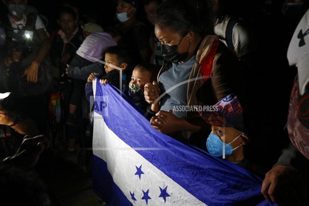 Delmer Martinez Honduran migrants who are trying to reach the U.S. pray as they try to cross the border in El Florido, Honduras into Guatemala, Friday, Jan. 15, 2021. The group quickly dispersed along the heavily-trafficked highway to the border town of Agua Caliente. (AP Photo/Delmer Martinez)