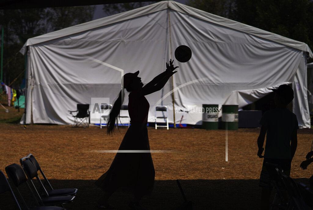 Marco Ugarte A young Ukrainian woman sets a ball at a refugee camp in the Iztapalapa borough of Mexico City, Tuesday, May 24, 2022. Mexico City will close the camp that has hosted hundreds of Ukrainian refugees for the past month now that a U.S. program vetting refugees and then allowing them to fly to the U.S. is operational and authorities say the camp is no longer needed. (AP Photo/Marco Ugarte)
