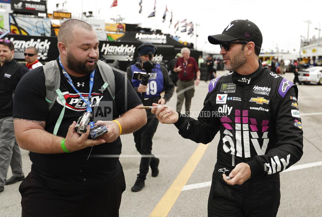 John Raoux Jimmie Johnson, right, hands a pen back to a fan after signing an autograph before a NASCAR auto race practice at Daytona International Speedway, Saturday, Feb. 9, 2019, in Daytona Beach, Fla. (AP Photo/John Raoux)