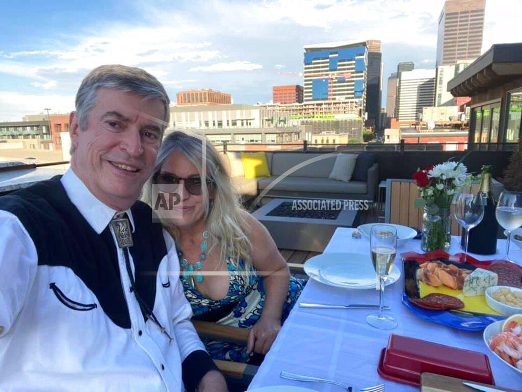 Peter Batty This July 3, 2020 image provided by Peter Batty shows him and his wife celebrating their anniversary and the opening night of the Santa Fe Opera on their balcony in Denver, Colo. The famed opera is offering a series of virtual performances after being forced to cancel the 2020 season due to the coronavirus pandemic. The Saturday night events are meant to celebrate the five originally-scheduled operas that would have been performed this summer. (Peter Batty via AP)