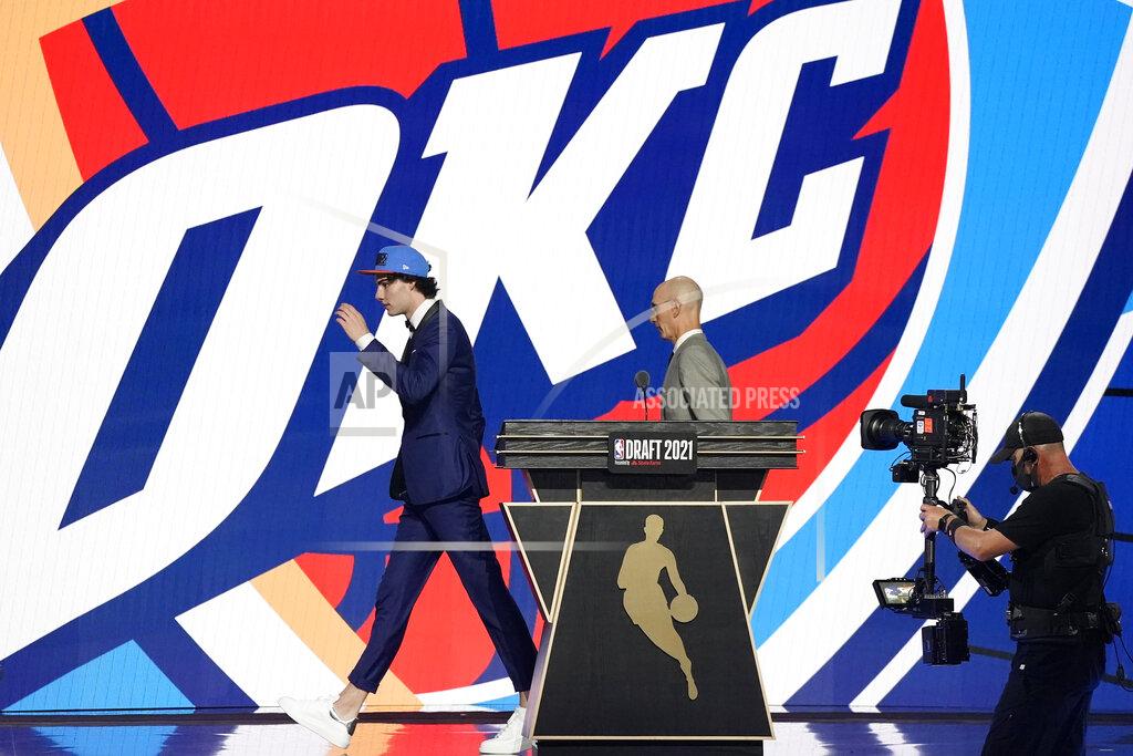 Corey Sipkin CORRECTS SPELLING TO GIDDEY, INSTEAD OF GIDDY - CORRECTS TEAM TO OKLAHOMA CITY THUNDER, INSTEAD OF GOLDEN STATE WARRIORS - Josh Giddey, left, walks off the stage with NBA Commissioner Adam Silver after being selected sixth overall by the Oklahoma City Thunder during the NBA basketball draft, Thursday, July 29, 2021, in New York. (AP Photo/Corey Sipkin)