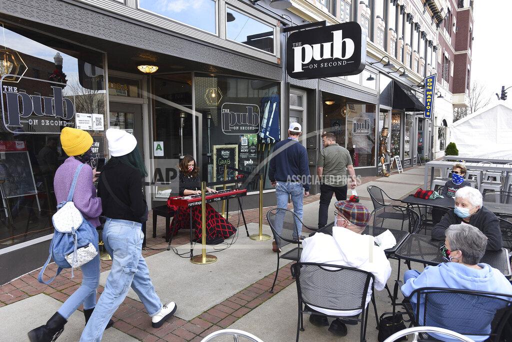 Alan Warren Diane Earle, principal piano with the Owensboro Symphony, plays Christmas music on an electronic piano during a random pop-up performance on Friday during lunchtime outside The Pub on Second in Owensboro, Ky., Friday, Dec. 11, 2020. The performance was provided by the Owensboro Symphony through the Music on Call program to add some entertainment and spread some holiday cheer. (Alan Warren/The Messenger-Inquirer via AP)