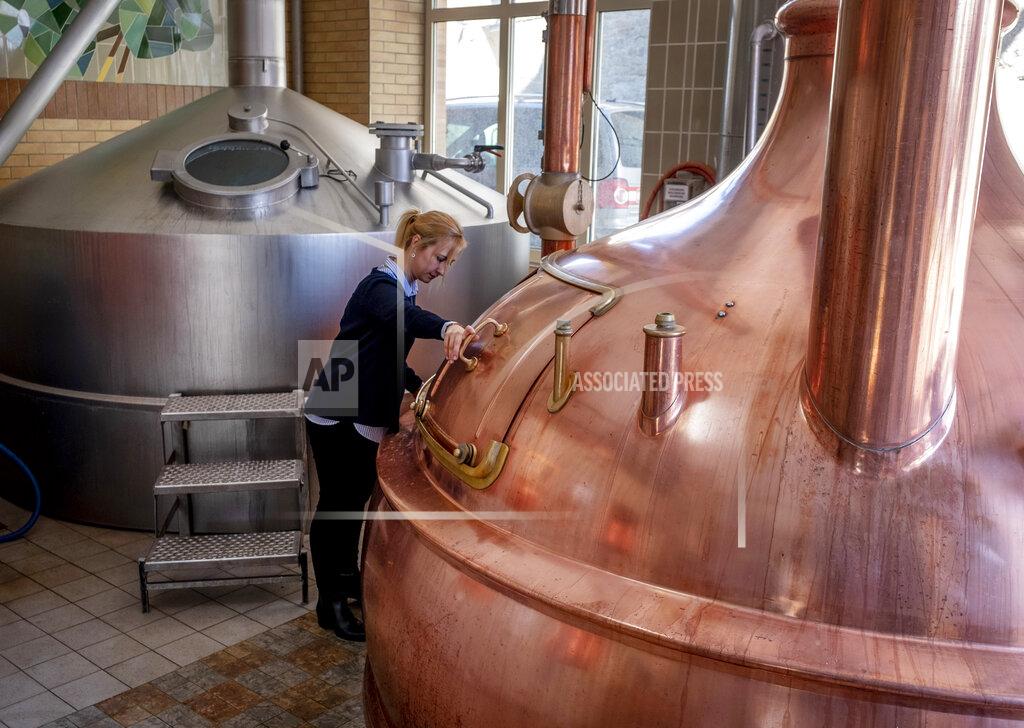 Michael Probst In this , Friday, April 17, 2020 photo junior director Christine Lang of the "Wernecker brewery" stands in the brewhouse of the brewery in Werneck, Germany. Due to the impact of the coronavirus the traditional brewery has to close 400 years after its foundation. (AP Photo/Michael Probst)