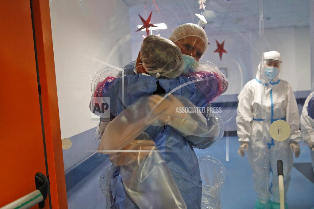 Alessandra Tarantino Ela Gubbiotti hugs her partner Giancarlo Vannimartini, an anesthesiologist who has been hospitalized for 10 days, in a safe room where patients and relatives can hug each other protected by a plastic film screen set up inside the COVID-19 ward of the Ospedale dei Castelli Hospital in Ariccia, near Rome, Wednesday, Jan. 20, 2021. (AP Photo/Alessandra Tarantino)
