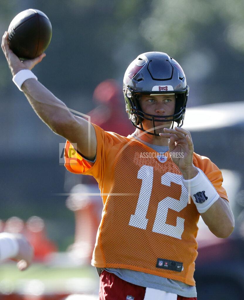 FILE - Tampa Bay Buccaneers quarterback Tom Brady (12) throws during an NFL football organized team activity Thursday, Aug. 13, 2020, in Tampa, Fla. Tom Brady has shifted the NFC South spotlight to Tampa Bay, but Drew Brees and the New Orleans Saints are still the three-time defending division champions. The battle of the NFL’s all-time leading passers brings extra drama to the division race. (AP Photo/Chris O'Meara, File)