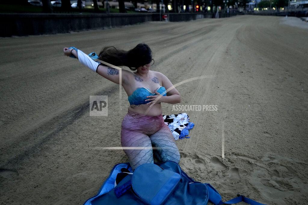 Mark Baker Lauren Metzler, founder of Sydney Mermaids, prepares for a swim at Manly Cove Beach in Sydney, Australia, Thursday, May 26, 2022. There is a strong need, especially after COVID-related lockdowns, to simply play and enjoy creativity, Metzler says. (AP Photo/Mark Baker)