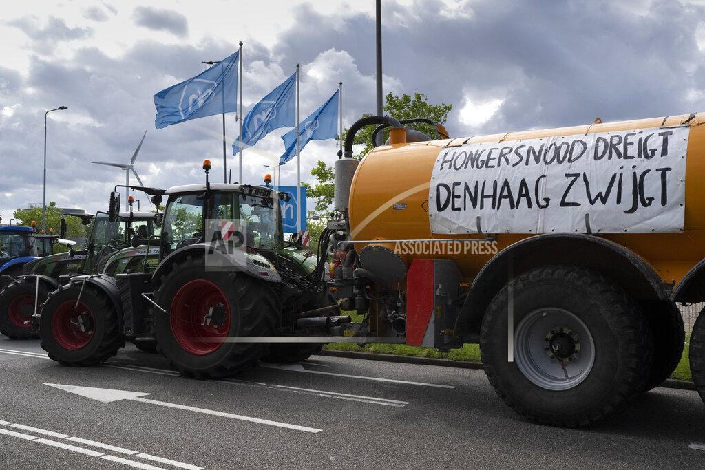 Peter Dejong A sign reads "Menace of Famine, The Hague Remains Silent" as some 25 tractors put up a blockade outside a distribution center for supermarket chain Albert Heijn in the town of Zaandam, just north of Amsterdam, Monday, July 4, 2022. Dutch farmers angry at government plans to slash emissions used tractors and trucks Monday to blockade supermarket distribution centers, the latest actions in a summer of discontent in the country's lucrative agricultural sector. (AP Photo/Peter Dejong)