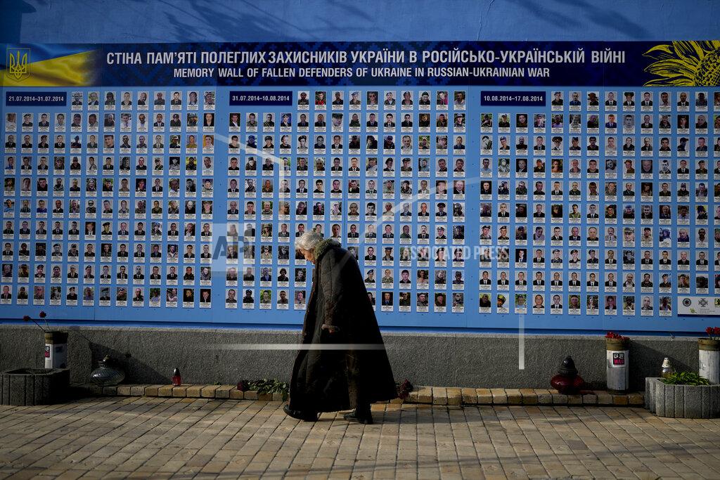 Natacha Pisarenko A woman walks past the Memorial Wall of Fallen Defenders of Ukraine in Russian-Ukrainian War in Kyiv, Ukraine, Monday, May 23, 2022. (AP Photo/Natacha Pisarenko)