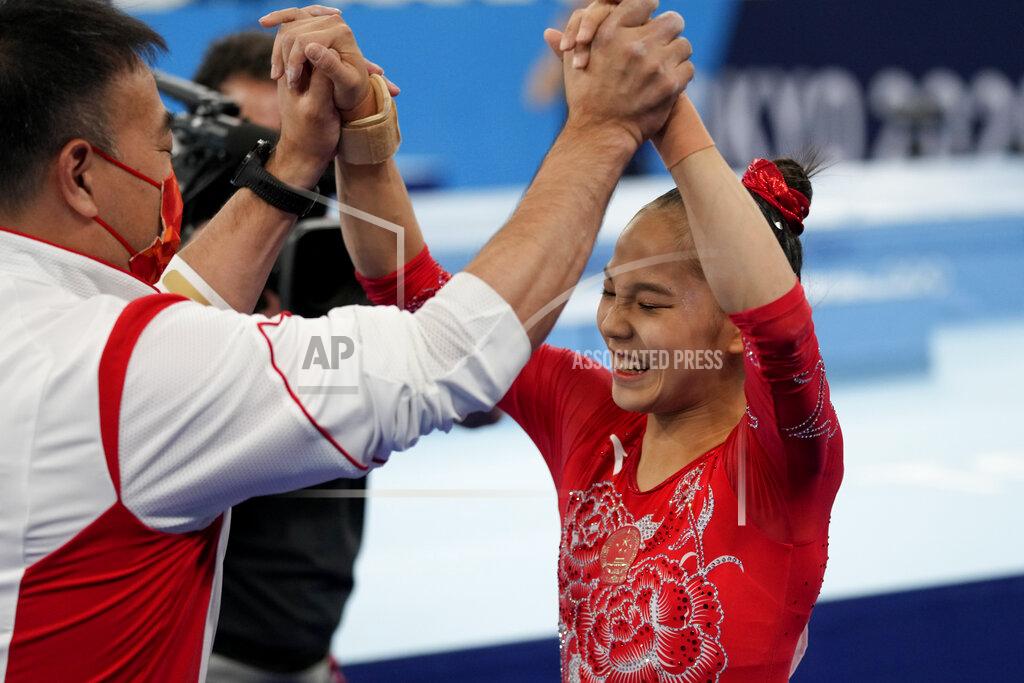 Ashley Landis Tang Xijing, of China, celebrates with her coach after performing on the balance beam during the artistic gymnastics women's apparatus final at the 2020 Summer Olympics, Tuesday, Aug. 3, 2021, in Tokyo, Japan. (AP Photo/Ashley Landis)