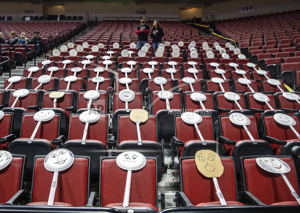 Chris Machian The Auburn fan section got creative by placing paper plate faces on the seats during the Class 1C boys high school basketball tournament championship game against Ogallala at Pinnacle Bank Arena, Saturday, March 14, 2020, in Lincoln, Neb. Crowds were limited to staff and immediate family due to concerns over the coronavirus. For most people, the new coronavirus causes only mild or moderate symptoms. For some it can cause more severe illness, especially in older adults and people with existing health problems. (Chris Machian/Omaha World-Herald via AP)