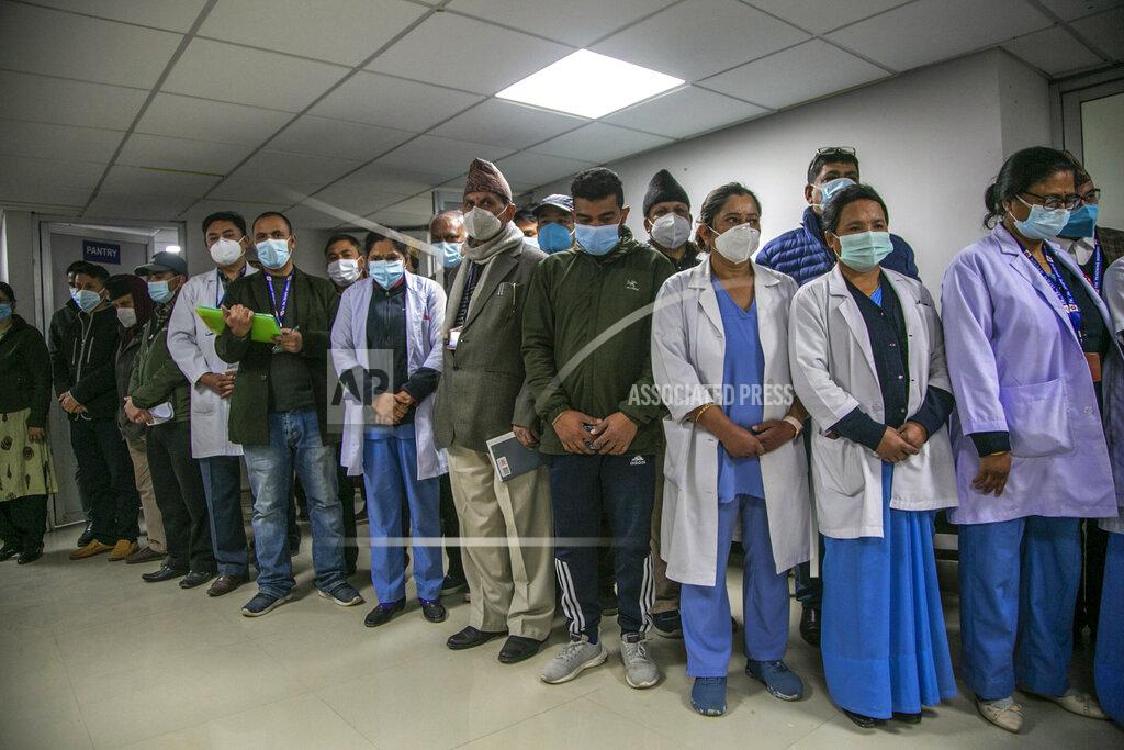 Niranjan Shrestha Nepalese health workers observe a minute of silence in memory of people who died due to COVID-19 before administering vaccine at Teaching Hospital in Kathmandu, Nepal, Wednesday, Jan. 27, 2021. Thousands of health workers lined up across Nepal to get the coronavirus vaccine Wednesday as the Himalayan nation began its campaign to get the population vaccinated within three months. Neighboring India gifted Nepal 1 million doses of the AstraZeneca-Oxford University vaccine manufactured under license by the Serum Institute of India. (AP Photo/Niranjan Shrestha)