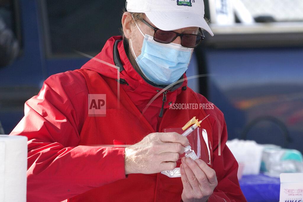 Ted S. Warren Dr. Greg Hoeksema fills a syringe with the Moderna COVID-19 vaccine, Thursday, March 4, 2021, at a drive-up mass vaccination site in Puyallup, Wash., south of Seattle. Officials said they expected to deliver approximately 2500 second doses of the Moderna COVID-19 vaccine at the site Thursday. (AP Photo/Ted S. Warren)