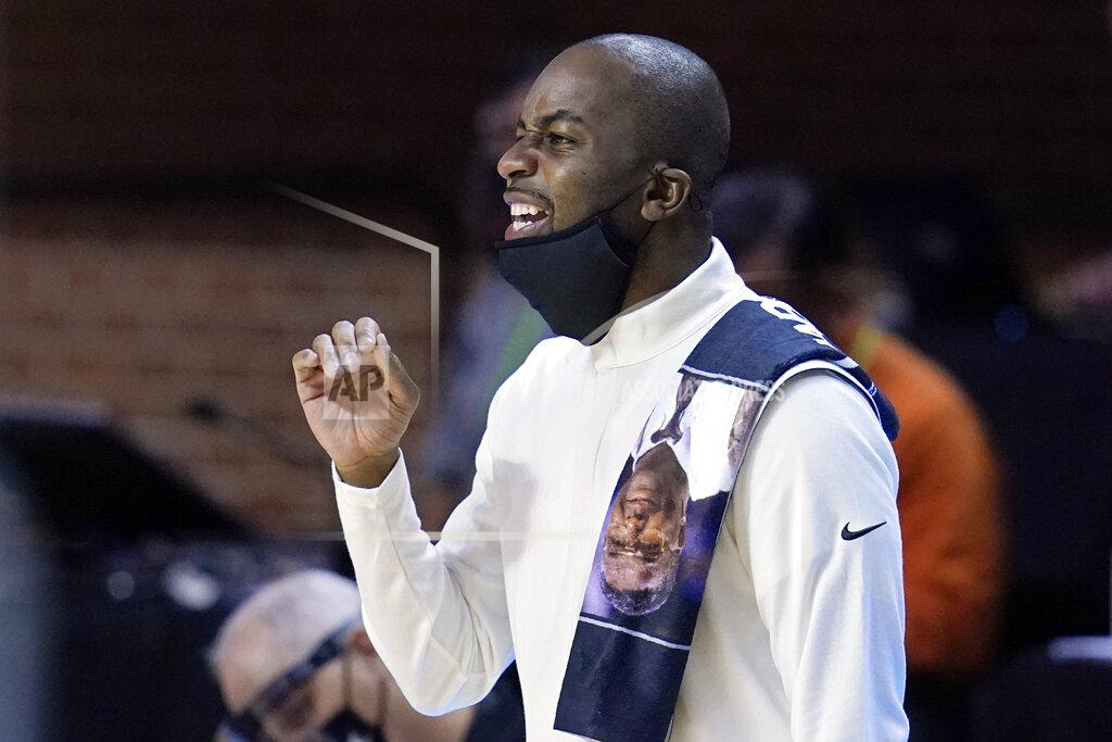 Sue Ogrocki Oklahoma State coach Mike Boynton Jr. wears a towel over his shoulder with a picture of John Thompson, the former Georgetown coach who died in August, during the team's NCAA college basketball game against Oral Roberts, Tuesday, Dec. 8, 2020, in Stillwater, Okla. Black coaches across the country are paying tribute to Thompson by wearing a towel over a shoulder, which was Thompson's trademark. (AP Photo/Sue Ogrocki)