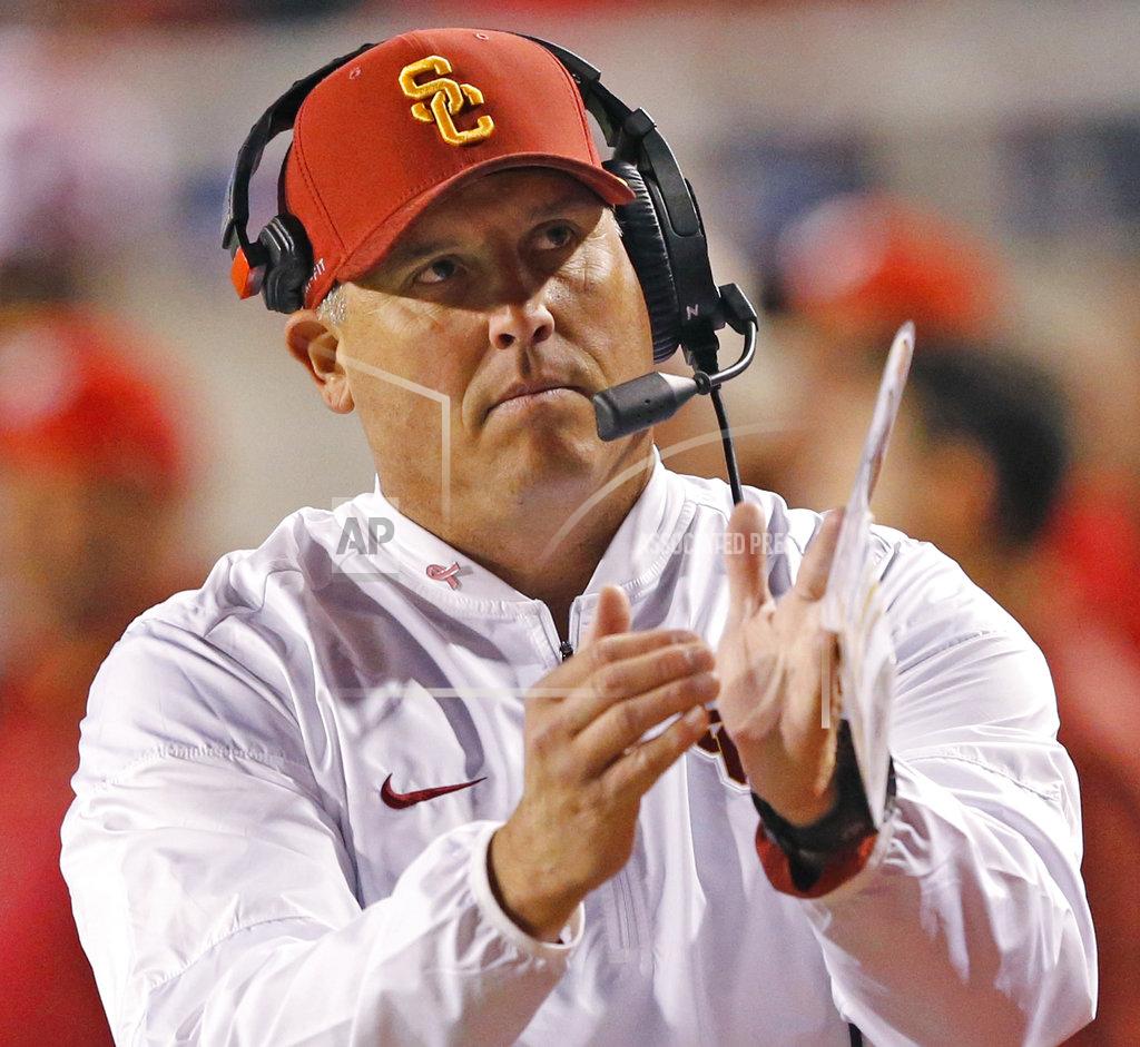Rick Bowmer FILE - In this Saturday, Oct. 20, 2018, file photo, Southern California head coach Clay Helton calls for a timeout in the first half of an NCAA college football game against Utah, in Salt Lake City. In a decision announced Tuesday, Nov. 27, 2018, offensive coordinator Tee Martin, defensive line coach Kenechi Udeze and defensive backs coach Ronnie Bradford are not being retained by Helton following the Trojans' first losing season in 18 years. (AP Photo/Rick Bowmer, File)