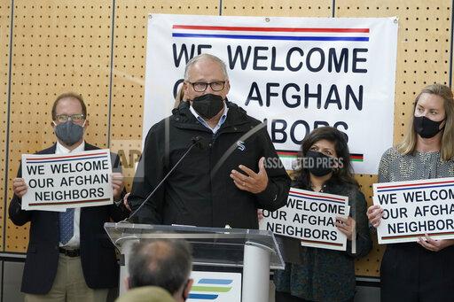 FILE - Washington Gov. Jay Inslee speaks during a news conference at the Afghan Welcome Center at the Seattle-Tacoma International Airport in Seattle, in this Friday, Oct. 22, 2021, file photo. Ordinary Americans and the nation's airlines are combining to donate miles and cash to help Afghan refugees resettle in the United States. Organizers said Tuesday, Oct. 26, 2021, they have raised enough donations pay for 40,000 flights, but they're hoping to nearly double that amount.(AP Photo/Ted S. Warren, File)