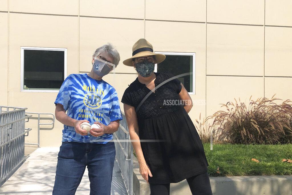 Janie Mccauley Maya Lin School Principal Judith Goodwin, left, holds foul balls alongside Alameda Arts after care co-founder Hazel Seiden outside of the elementary school in Alameda, Calif., Wednesday, Sept. 16, 2020. (AP Photo/Janie McCauley)