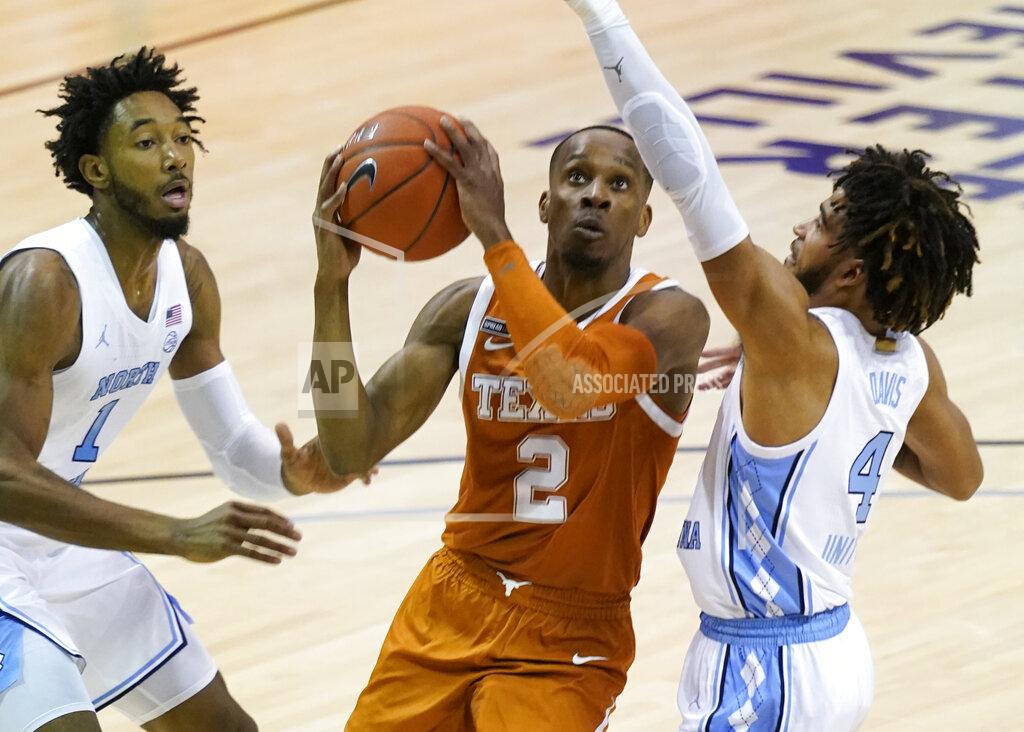 Kathy Kmonicek Texas guard Matt Coleman III (2) takes aim at the basket between North Carolina guard Leaky Black (1) and guard R.J. Davis (4) in the first half of an NCAA college basketball game for the championship of the Maui Invitational, Wednesday, Dec. 2, 2020, in Asheville, N.C. Texas won 69-67. Coleman was the MVP with the winning basket and high score of 22 points. (AP Photo/Kathy Kmonicek)