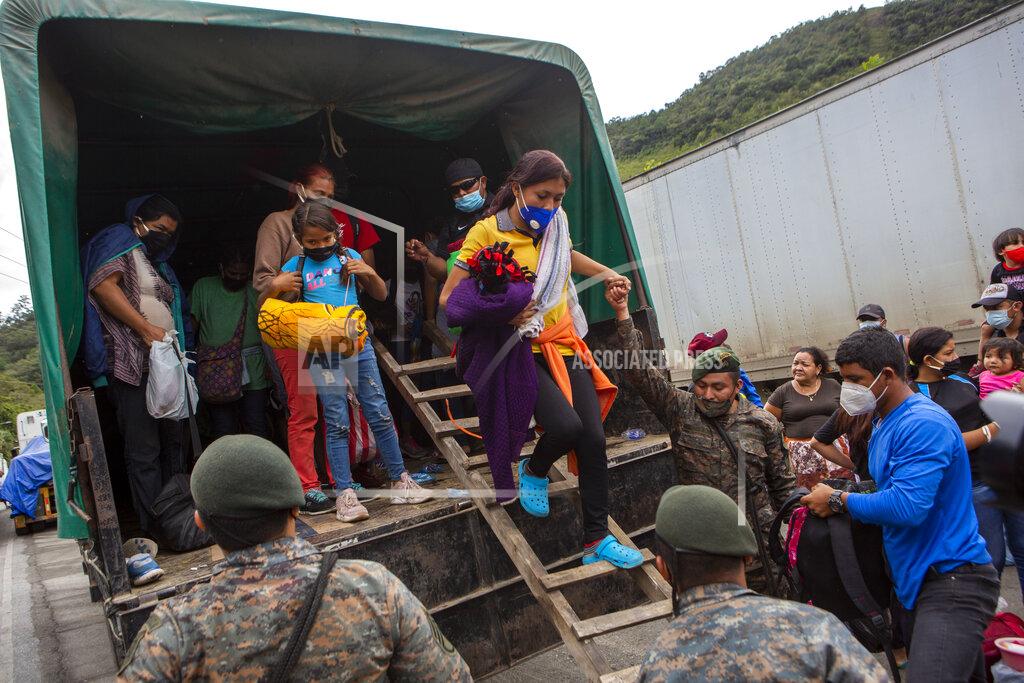 Oliver De Ros A Honduran migrant woman is helped off a Guatemalan army truck after being returned to El Florido, Guatemala, one of the border points between Guatemala and Honduras, Tuesday, Jan. 19, 2021. A once large caravan of Honduran migrants that pushed its way into Guatemala last week had dissipated by Tuesday in the face of Guatemalan security forces. (AP Photo/Oliver de Ros)