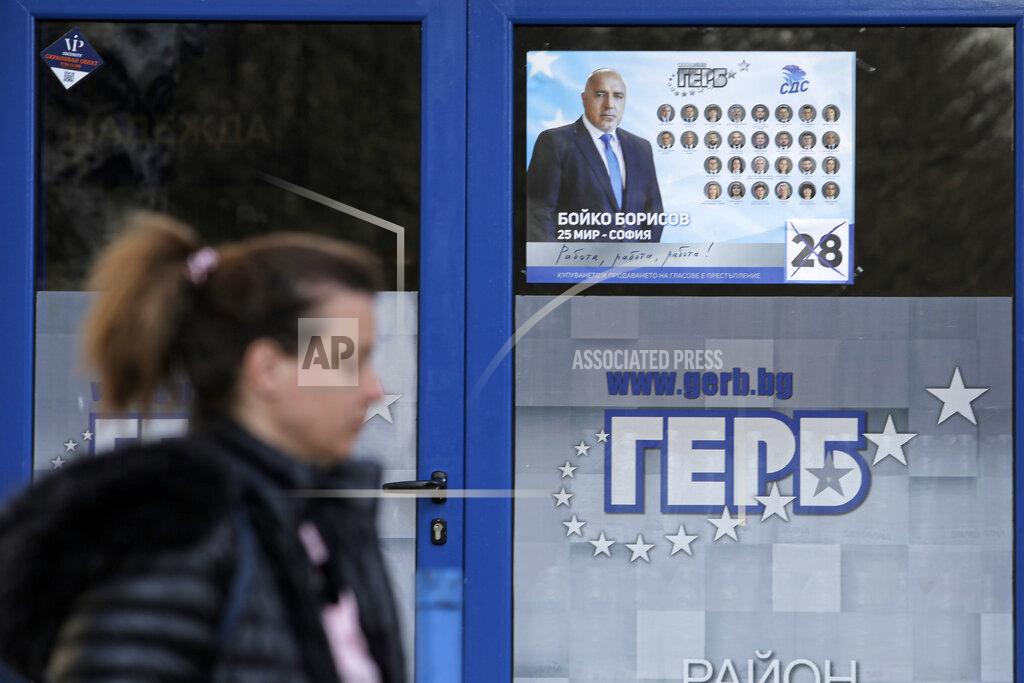 Valentina Petrova A woman passes by a poster depicting Bulgarian prime minister Boyko Borissov, in Sofia, Bulgaria, Wednesday, March 31, 2021. After months of nationwide anti-government protests over corruption, stalled reforms and a stagnating economy in the EU's poorest member state, Bulgarians are gearing up for a parliamentary election overshadowed by a deadly pandemic. (AP Photo/Valentina Petrova)