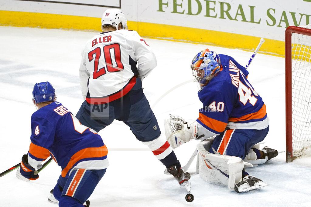 Kathy Willens New York Islanders goaltender Semyon Varlamov (40) makes a save with Washington Capitals center Lars Eller (20) in front of the crease and Islanders defenseman Andy Greene (4) watching during the second period of an NHL hockey game Thursday, April 22, 2021, in Uniondale, N.Y. (AP Photo/Kathy Willens)