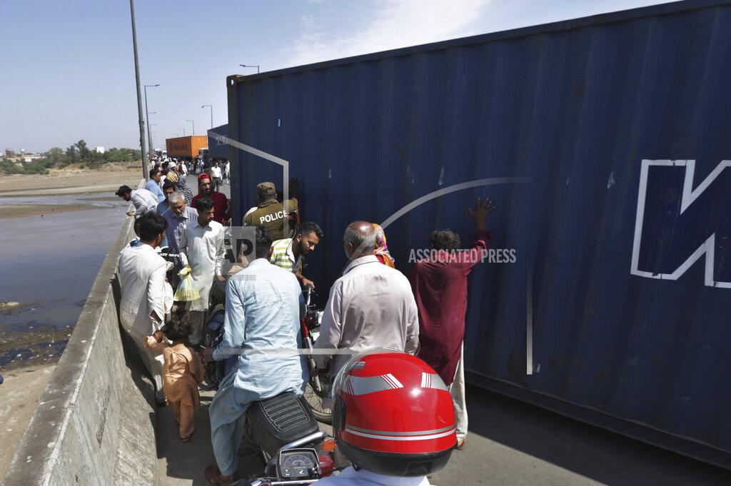 K.M. Chaudary People cross a bridge on Ravi River which is closed for traffic due to shipping containers placed by authorities in an attempt to foil a planned protest of Pakistan's main opposition party, in Lahore, Pakistan, Tuesday, May 24, 2022. Pakistan's key opposition party led by recently ousted Prime Minister Imran Khan accused police of detaining hundreds of its supporters in raids that started early Tuesday. (AP Photo/K.M. Chaudary)