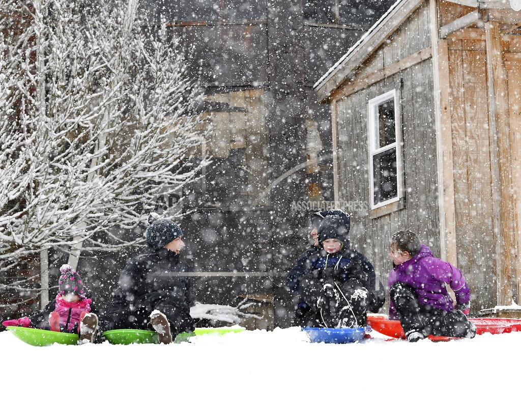 Mark Stockwell Kids and their parents get ready to push off on top of a popular sledding hill in North Attleboro, Mass. Sunday, Feb. 7, 2021. A quick moving storm dumped several inches of new snow in the area. (Mark Stockwell/The Sun Chronicle via AP)