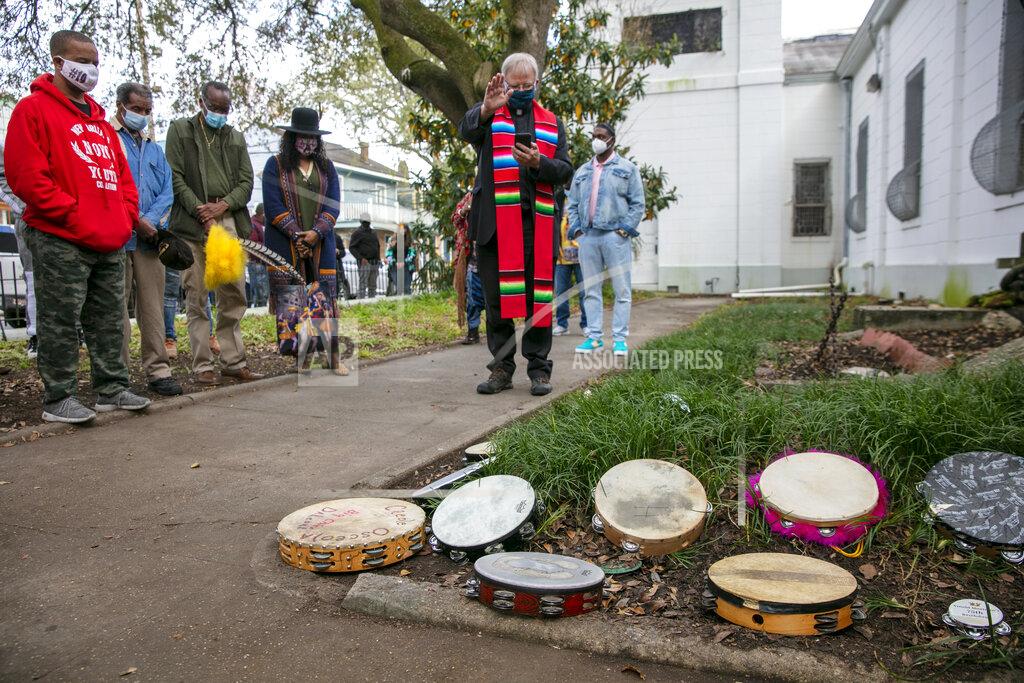 Father Dwight Hoeberechts blesses tambourines outside St. Augustine Catholic Church for the start of Twelfth Night in New Orleans on Wednesday, Jan. 6, 2021. The blessing was also part of this year's Big Chief Tootie Montana Day as proclaimed by the city of New Orleans. (Chris Granger/The Times-Picayune/The New Orleans Advocate via AP)