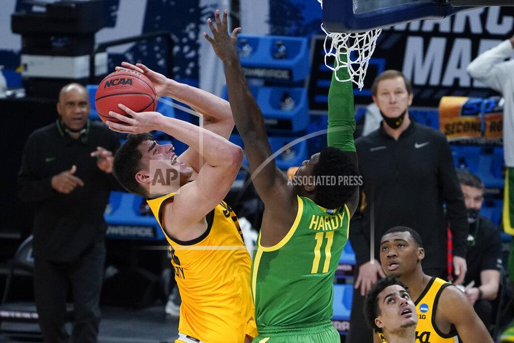 Iowa center Luka Garza (55) shoots on Oregon guard Amauri Hardy (11) during the first half of a men's college basketball game in the second round of the NCAA tournament at Bankers Life Fieldhouse in Indianapolis, Monday, March 22, 2021. (AP Photo/Paul Sancya)