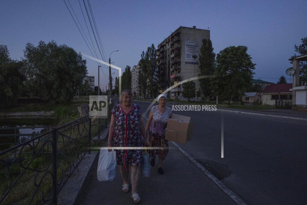 Nariman El-Mofty 70-year-old Valentyna Klymenko, left, who lives alone in her war-damaged building from Russian aerial bombs, without electricity and water, walks with her friend back to her apartment, in Borodyanka, Kyiv region, Ukraine, Tuesday, June 28, 2022. Then Klymenko returns, alone, to an apartment that used to be noisy and full of life. Now, instead of the voices of her great-grandchildren, she is greeted by dim, damp rooms. She rarely cooks. She drinks fruit compote and eats canned tomatoes, which she prepared last year, so as not to waste the gas in her portable stove. (AP Photo/Nariman El-Mofty)