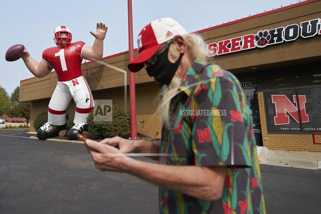 Nati Harnik A Nebraska fan stops to take a picture of a giant inflatable football player standing in front of the Husker Hounds sports apparel store in Omaha, Neb., Wednesday, Sept. 16, 2020. It was put up Wednesday after the Big Ten conference changed course Wednesday and said it plans to begin its NCAA college football season the weekend of Oct. 23-24. Each team will have an eight-game schedule. (AP Photo/Nati Harnik)
