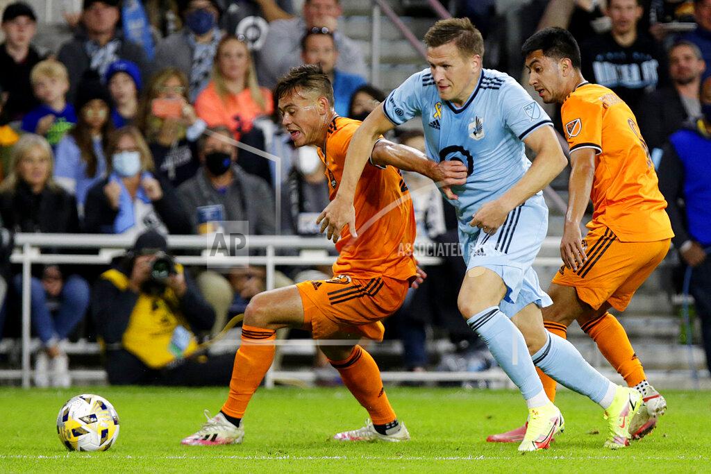 Andy Clayton-King Minnesota United midfielder Robin Lod (17) splits Houston Dynamo defender Sam Junqua (29) and Dynamo midfielder Memo Rodriguez (8) during the second half of an MLS soccer match, Saturday, Sept. 25, 2021, in St. Paul, Minn. (AP Photo/Andy Clayton-King)