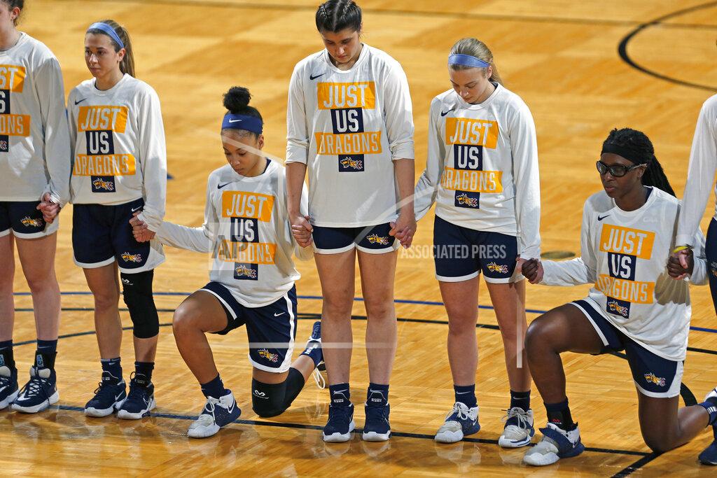 Ronald Cortes Drexel players stand and kneel while the National Anthem is played before the start of the first half of a college basketball game against Georgia in the first round of the women's NCAA tournament at the Greehey Arena in San Antonio, Texas, Monday, March 22, 2021. (AP Photo/Ronald Cortes)