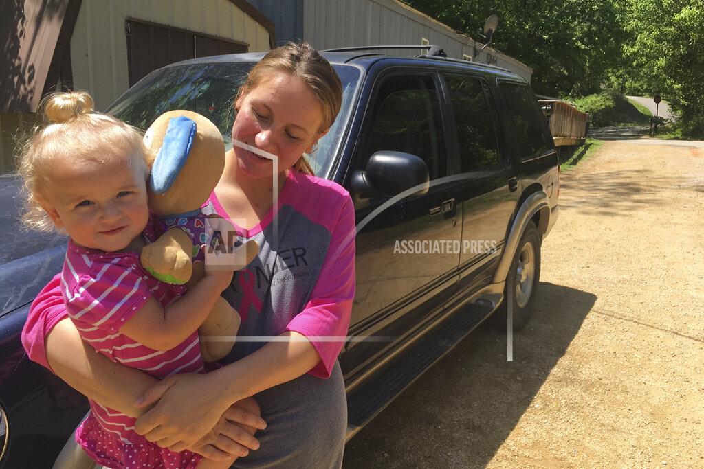 FILE - In this May 7, 2018, file photo, Mariah Kolka holds her daughter, Sophia, 1, outside her Linden, Tenn., home after meeting with advocates from an anti-poverty group, Save the Children. The Mass Poor People’s Assembly & Moral March on Washington aims to build upon the nation’s principles to pursue solutions to poverty — something advocates say is getting especially severe in rural areas. (AP Photo/Russell Contreras, File)