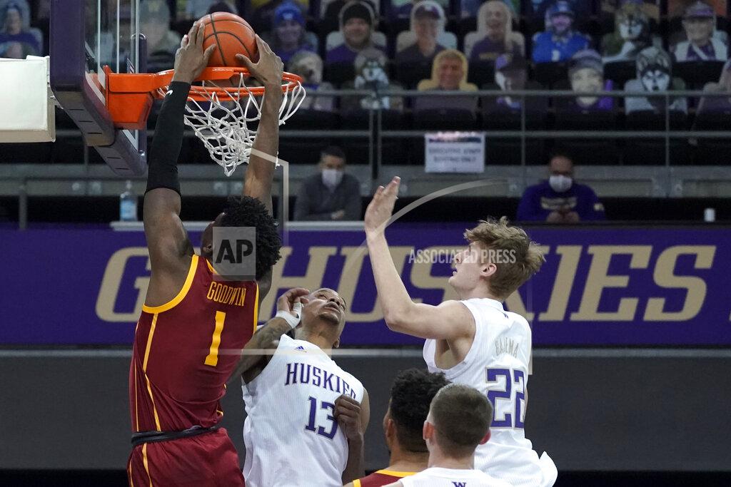 Ted S. Warren Southern California forward Chevez Goodwin (1) dunks over Washington forward Hameir Wright (13) and guard Cole Bajema (22) during the first half of an NCAA college basketball game Thursday, Feb. 11, 2021, in Seattle. (AP Photo/Ted S. Warren)