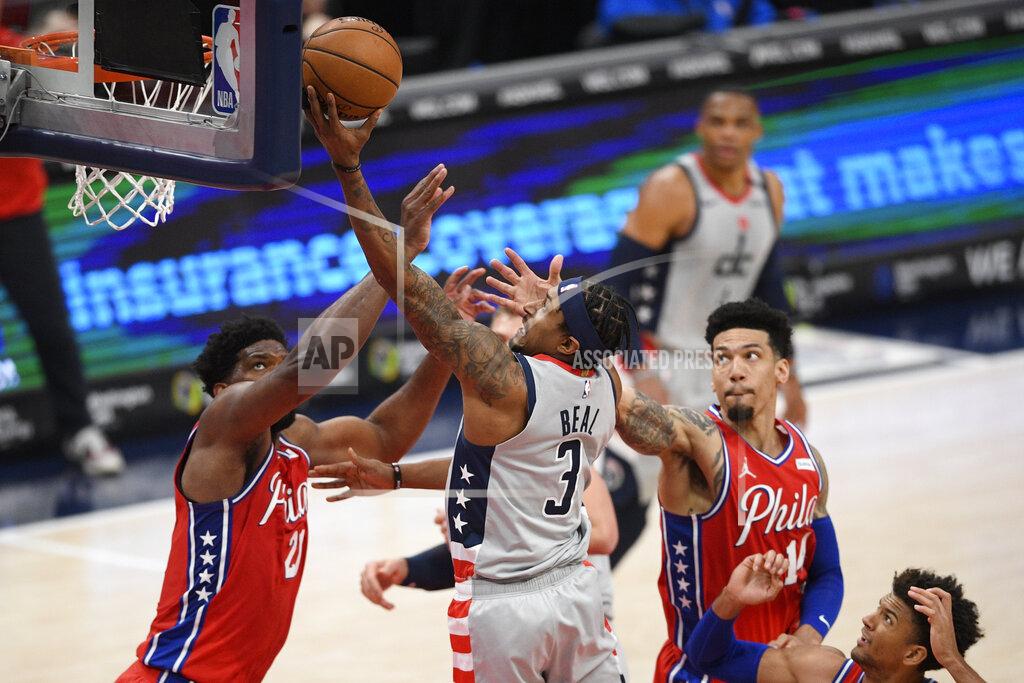 Nick Wass Washington Wizards guard Bradley Beal (3) goes to the basket past against Philadelphia 76ers center Joel Embiid (21) and forward Danny Green (14) during the first half of an NBA basketball game Friday, March 12, 2021, in Washington. (AP Photo/Nick Wass)