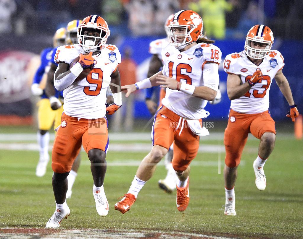 Mike Mccarn FILE - In this Saturday, Dec. 1, 2018, file photo, Clemson's Travis Etienne (9) followed by quarterback Trevor Lawrence (16) runs for a touchdown against Pittsburgh in the first half of the Atlantic Coast Conference championship NCAA college football game in Charlotte, N.C. Clemson’s high-octane offense is led by the pair of young, talented offensive players. (AP Photo/Mike McCarn, File)