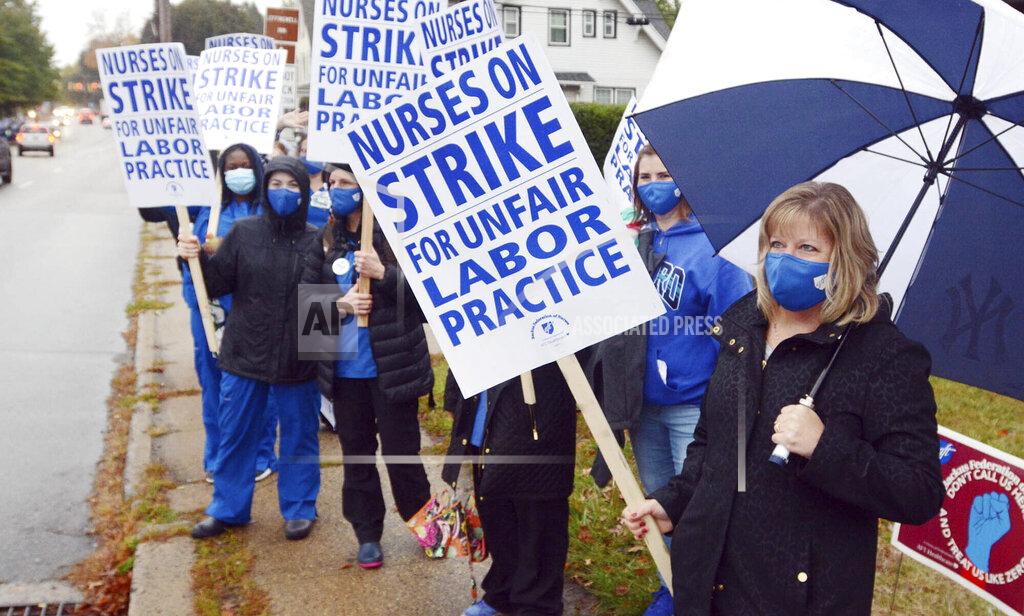 Registered nurse Julie Prochorena, right, of Colchester, Conn., joins a group of about 200 nurses and their supporters as they began a two-day strike outside the William W. Backus Hospital in Norwich, Conn., Tuesday, Oct. 13, 2020. The strike comes amid a breakdown in contract talks between the nurses' union and hospital management, as well as rising coronavirus cases in Norwich and other eastern Connecticut communities. The hospital is operated by Hartford HealthCare. (John Shishmanian/The Bulletin via AP)