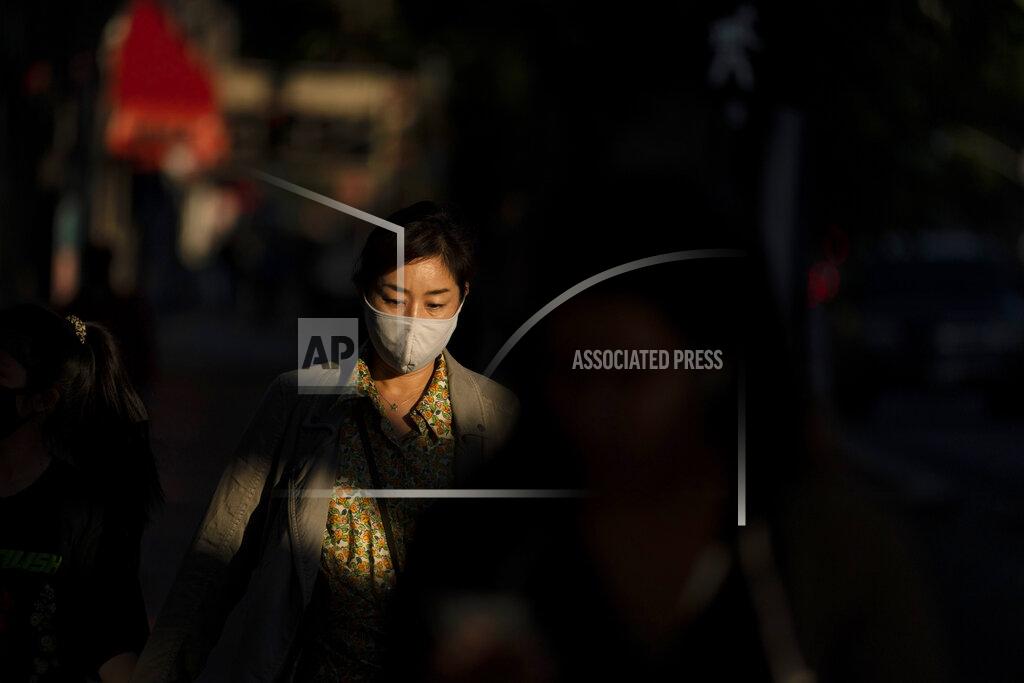 Jae C. Hong FILE - In this Nov. 12, 2020, file photo, a woman wearing a face mask walks along the street in the Hollywood section of Los Angeles. With the coronavirus coming back with a vengeance across the country and the U.S. facing a long, dark winter, governors and other elected officials are showing little appetite for reimposing the kind of lockdowns and large-scale business closings seen last spring. (AP Photo/Jae C. Hong, File)