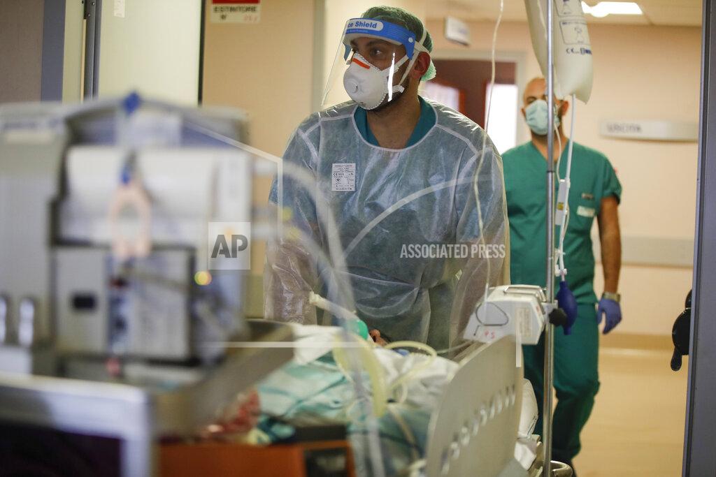Luca Bruno Doctors carry a coronavirus patient in the Intensive Care Unit at Varese’s Circolo hospital, in Varese, Italy, Friday, Nov. 6, 2020. During Italy's autumn pandemic resurgence, concern is falling less on intensive care wards and more on regular medical wards, as eight regions have seen the needle move alarmingly into the red-alert zone with more than half of hospital beds dedicated to coronavirus patients. (AP Photo/Luca Bruno)