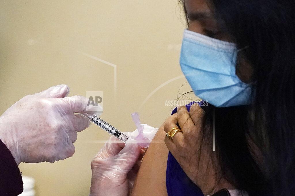 Airlift Northwest flight nurse Mikaela Hagberg looks on as she receives one of the first COVID-19 vaccinations at UW Medicine Tuesday, Dec. 15, 2020, in Seattle. (AP Photo/Elaine Thompson)