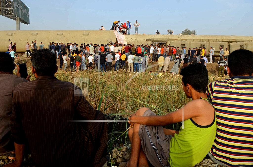 Tarek Wagih People gather at the site where a passenger train derailed injuring at least 100 people, near Banha, Qalyubia province, Egypt, Sunday, April 18, 2021. At least eight train wagons ran off the railway, the provincial governor's office said in a statement. (AP Photo/Tarek Wagih)