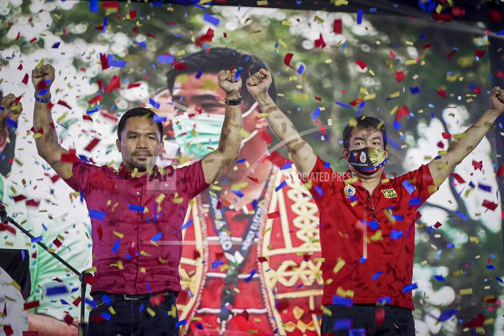 Uncredited In this photo provided by the Manny Pacquiao MediaComms, Senator Manny Pacquiao, left, raises his hands during a national convention of his PDP-Laban party in Quezon city, Philippines on Sunday Sept. 19, 2021. Philippine boxing icon and senator Manny Pacquiao says he will run for president in the 2022 elections. (Manny Pacquiao MediaComms via AP)